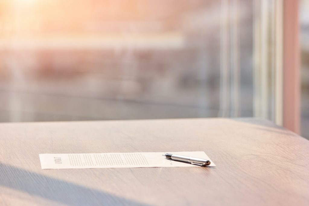 Contract paper sheet and pen on the table.